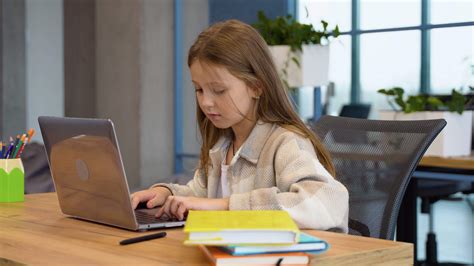 Student girl doing her homework using laptop in primary school 49537505