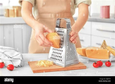 Woman Grating Cheese On Kitchen Table Stock Photo Alamy