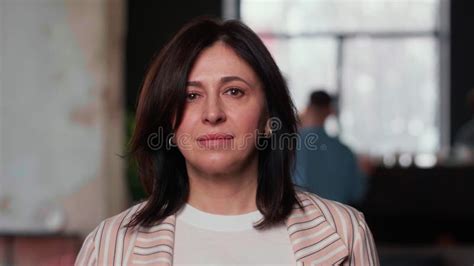 Beautiful Serious Middle Aged Brunette Boss Business Woman Looking At Camera Touching Hair At