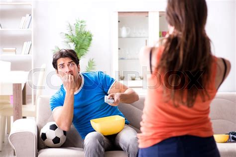 Wife unhappy that husband is watching | Stock image | Colourbox