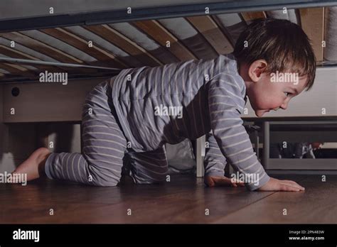 Toddler Baby Crawls And Hides Under The Bed Child Climbed Under The