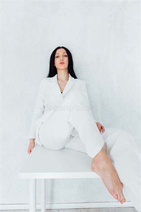 Fashionable Brunette Woman In White Suit Sitting On Table Stock Image Image Of Posing Hands