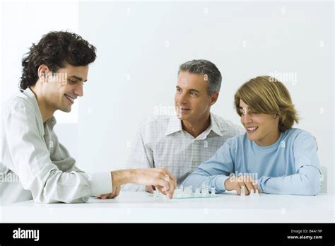 Mature Father And Two Sons Playing Chess All Smiling Stock Photo Alamy