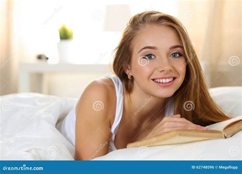 Jeune Belle Femme Blonde De Sourire Se Situant Dans Le Livre De Lecture