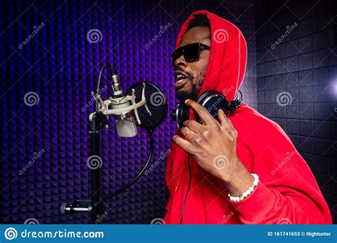 Afro American Man Headphones In A Cap And A Hood Sunglasses Recording