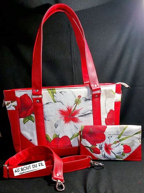 A Red And White Floral Bag With Matching Purse Wrist Strap And Keychain