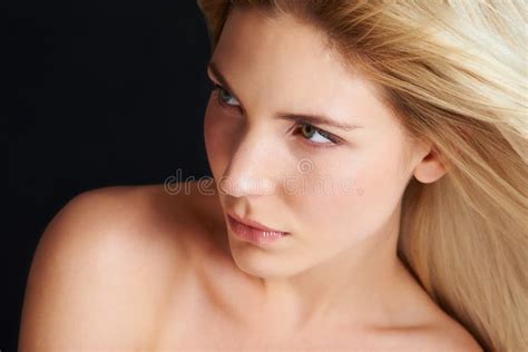 Beauty Up Close And Personal A Blonde Woman Posing In Front Of A Black Background While The