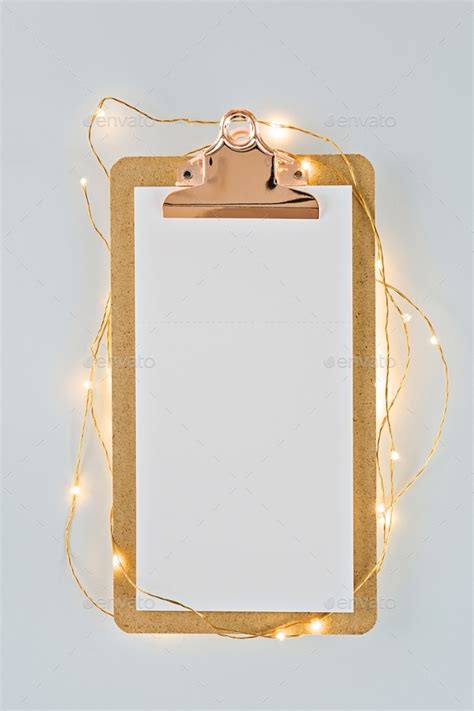 Blank notes sheet on clipboard with led-lights on white background ...