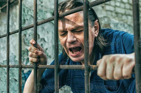 A Depressed Man In Handcuffs Behind Bars A Depressed Arrested Male