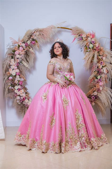 Vestido de 15 años color rosado con aplicaciones doradas en corset