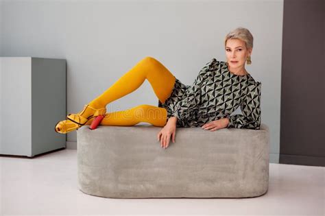 Sexy Mature Femme à La Mode Cheveux Courts Couché En Studio Porter Mini Jupe Et Collants Jaune
