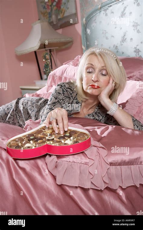 Woman Lying In Bed Eating Chocolates Stock Photo Alamy