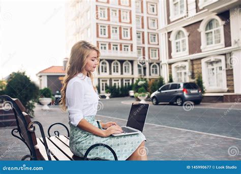 Pretty Blonde Business Woman Working On Laptop On Banch In City She Wears White Shirt Blue