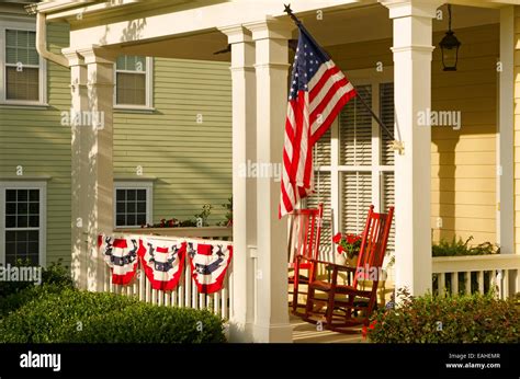 An American Flag And Buntings Hang From A Front Porch Of An Upscale