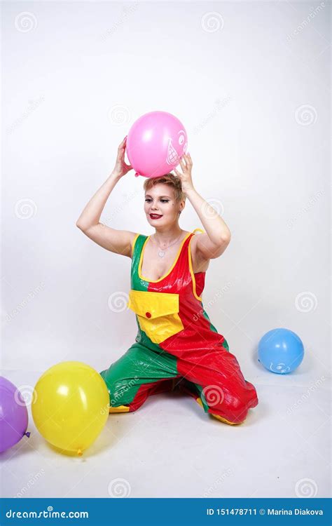 Cute Chubby Girl With Short Blonde Hair And Plus Size Figure In Bright Colored PVC Jumpsuit