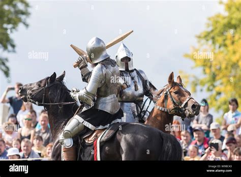 Two men knights riding horses on the battlefield and having a fight on ...