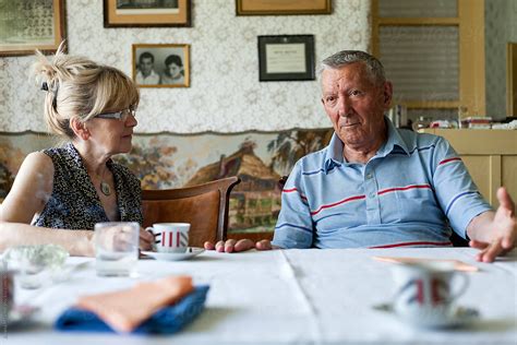 Elderly People Having A Conversation After Lunch By Stocksy