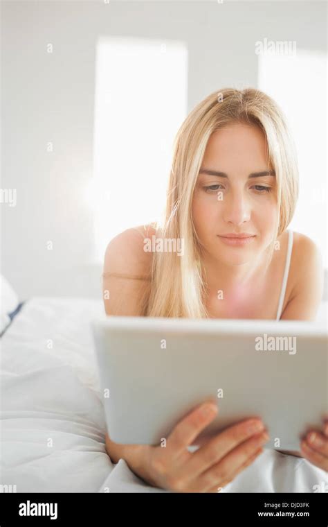 Pretty Blonde Using Digital Tablet On Her Bed Stock Photo Alamy