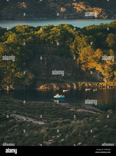 Tilt Shifted Image Of A Little Blue Fishing Boat In A Loch In The