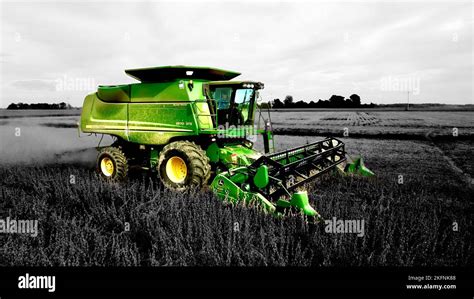 A Black And White Shot Of A Green John Deere Combine Harvesting