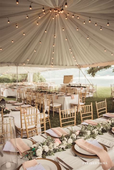 An Outdoor Tent With Tables And Chairs Set Up For A Wedding Reception