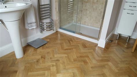 A Bathroom With Wooden Flooring And A Glass Enclosed Shower Stall Next