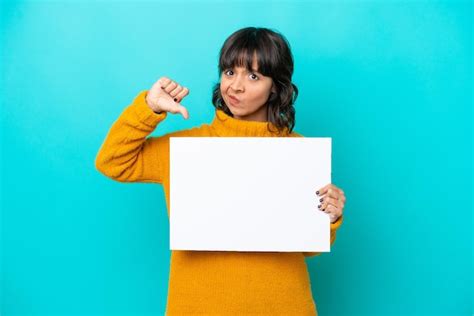 Joven Latina Aislada De Fondo Azul Sosteniendo Un Cartel Vac O Y Haciendo Mala Se Al Foto Premium
