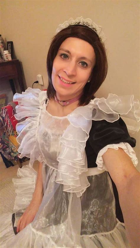 A Woman In A White Dress Is Sitting On The Floor With Her Hands Behind