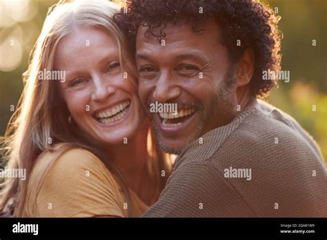 Portrait Of Loving Mature Couple Hugging Outdoors Against Flaring Evening Sun Stock Photo Alamy