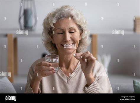 Head Shot Smiling Mature Woman Holding Water Glass And Pill Stock Photo Alamy
