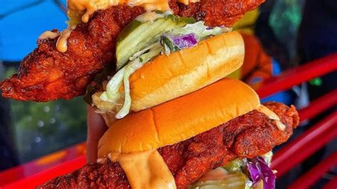 Delicious Stacked Chicken Sandwiches With Pickles And Sauce At Daves Hot Chicken Showcasing