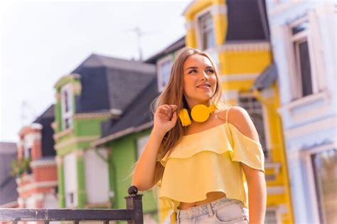 Portrait De Jeune Femme Blonde Dans Un Quartier Avec Des Maisons Aux Façades Colorées Derrière