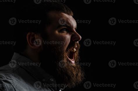 Naked Bearded Man Angrily Screams Into A Spray Of Water Against A Black Background With Copy