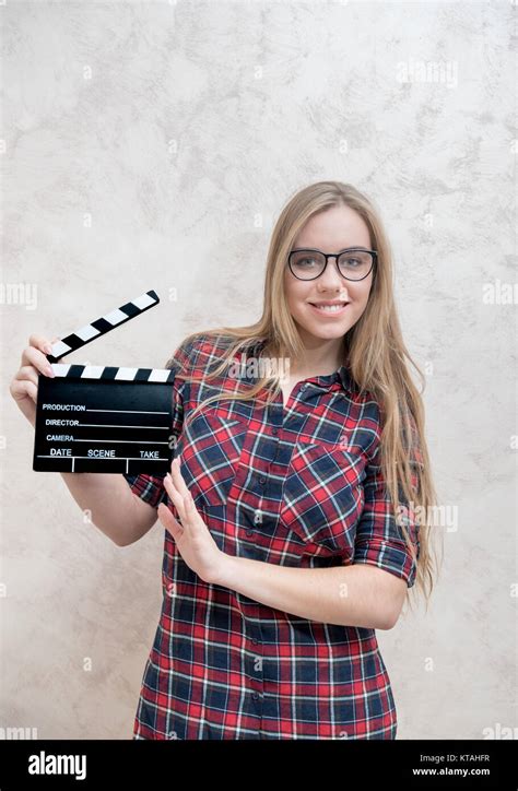 Junge blonde Frau Schauspielerin mit Movie clapper Board lächelnd und Kamera posieren