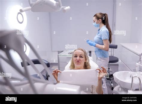 Woman In Dentistry Is Wearing Dental Bib For Patient Disposable Napkin