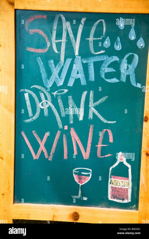 SPAIN Barcelona Save Water Drink Wine sign written on chalkboard in La ...