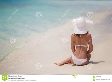 Belle Femme Dans Un Bikini Et Un Chapeau Blancs Sur La Plage Image