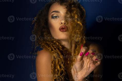 Charming Curly Blonde With Beautiful Make Up Makes Air Kiss In Studio Stock Photo At