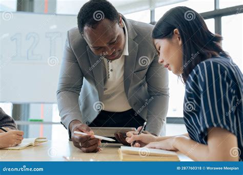 Mature Professor Talking To His Student While Assisting Her On A Class At The University Stock