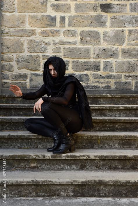Portrait Of Beautiful Female Model With Blonde Plait Wearing Black Leather Catsuit And Flowing