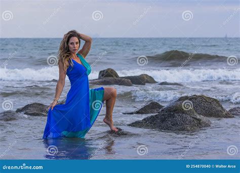 Un Bonito Modelo Latino De Brunette Se Encuentra En La Playa Al Atardecer Foto De Archivo
