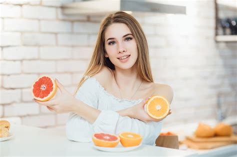 Jeune Femme Blonde De Beaut Prenant Son Petit D Jeuner Dans La Cuisine Avec Deux Pamplemousses
