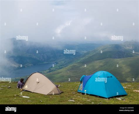 Campers wild camping tents on Snowdon summit with view from top to Llyn Cwellyn Snowdonia ...