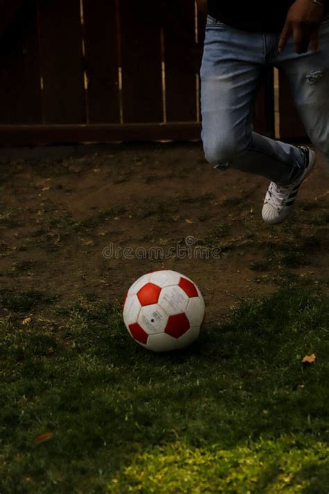 Vertical Shot Of The Legs Of A Person Running Towards A Football Ball