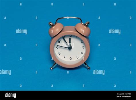 Brown Alarm Retro Clock On Blue Background Five Minutes To Twelve