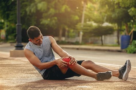 Homem corredor lesão no joelho em corrida esportiva mãos segurando