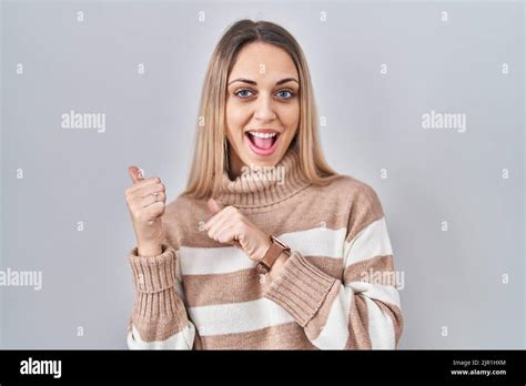 junge blonde Frau trägt einen Rollkragenpullover über einem isolierten Hintergrund der mit