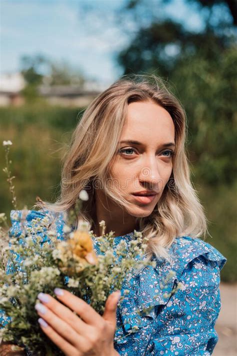 Beautiful Girl Holding Wildflowers And Duckling In Her Hands Stock