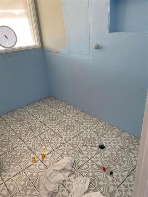 A Bathroom With Blue Walls And Tile Flooring That Needs To Be Painted