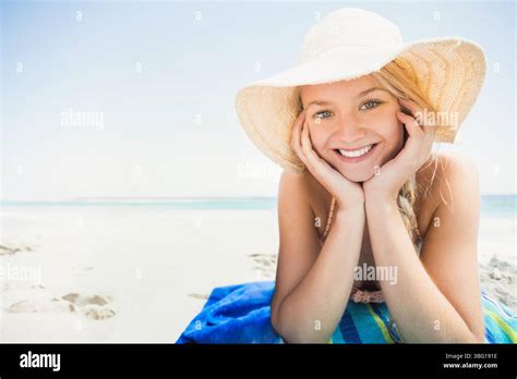 Woman Lying On Stomach Wearing Bikini Top And Straw Hat On Sandy Beach Towel Copy Space Stock